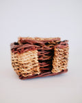Set of six vintage hand woven wicker drink coasters displayed around matching square holder - Eulogy Vintage