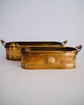Detail of vintage oval brass planter trough showing raised seashell emblem and rich aged patina - Eulogy Vintage
