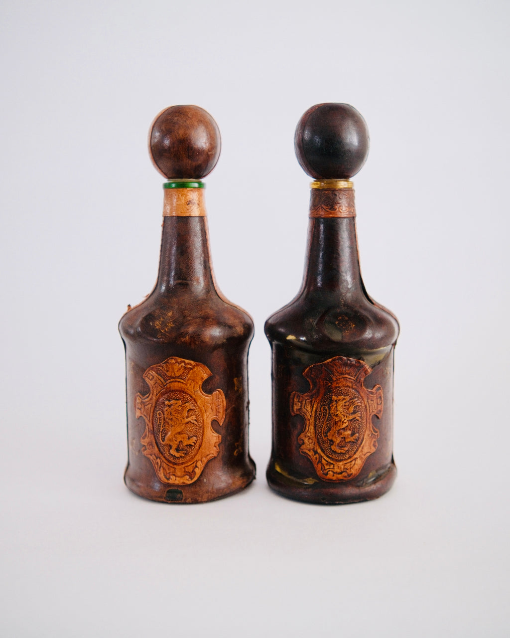 The Medici Pair | Mid-Century Italian Leather-Wrapped Decanters with Embossed Lion Crests